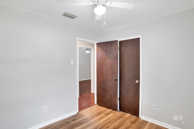 unfurnished bedroom with ceiling fan, a closet, and light hardwood / wood-style floors