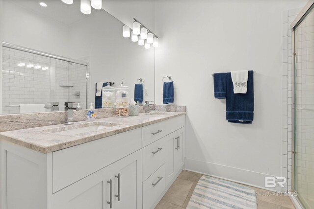full bath featuring tile patterned floors, a sink, double vanity, baseboards, and a shower stall