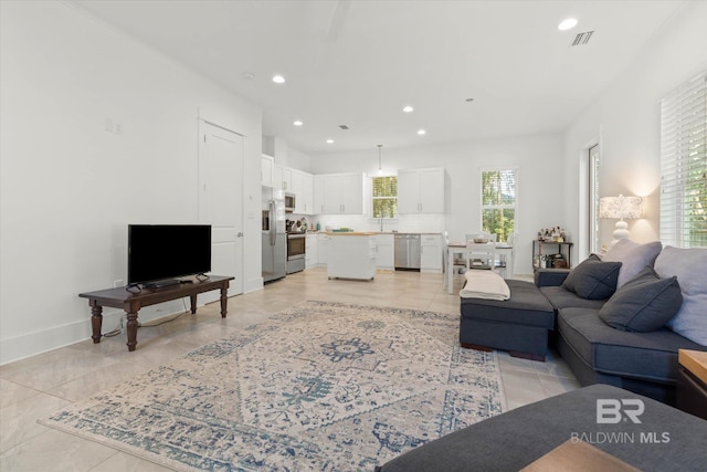 living room featuring baseboards, visible vents, and recessed lighting