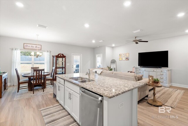 kitchen featuring white cabinetry, a center island with sink, decorative light fixtures, stainless steel dishwasher, and sink