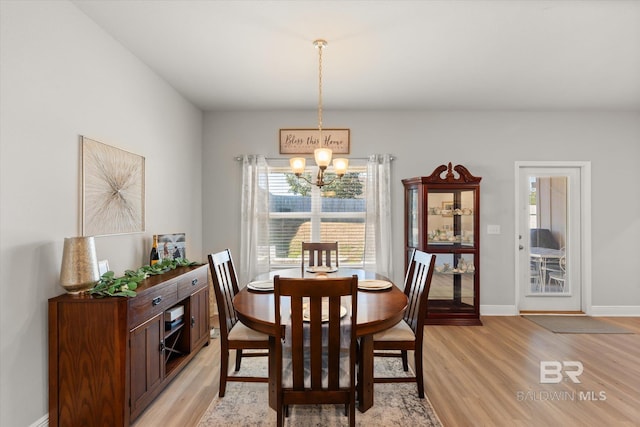 dining area featuring an inviting chandelier and light hardwood / wood-style floors