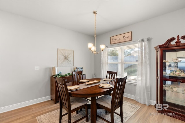 dining room featuring a wealth of natural light, a notable chandelier, and light wood-type flooring