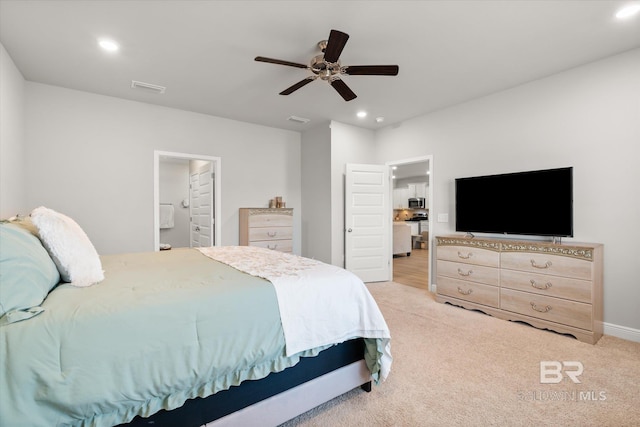 bedroom featuring ceiling fan, ensuite bathroom, and light carpet