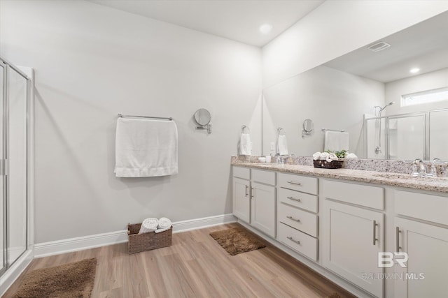 bathroom with a shower with shower door, hardwood / wood-style flooring, and vanity