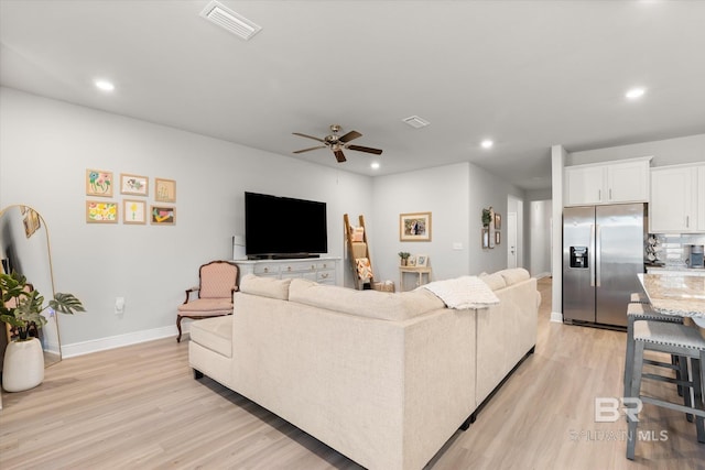 living room with ceiling fan and light hardwood / wood-style floors