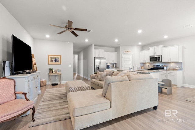 living room featuring ceiling fan and light wood-type flooring