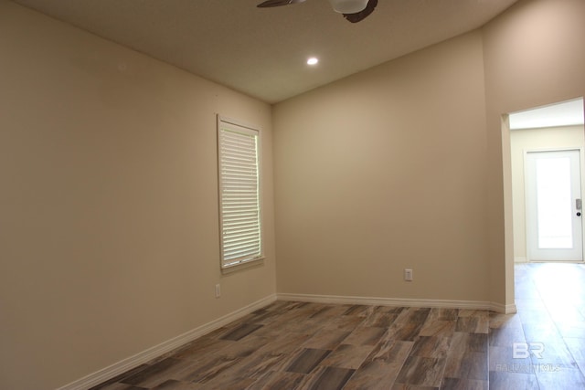 empty room featuring lofted ceiling, dark hardwood / wood-style floors, and ceiling fan