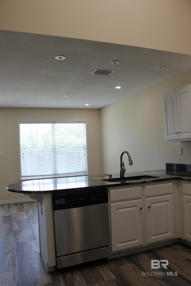 kitchen featuring sink, kitchen peninsula, white cabinets, and stainless steel dishwasher