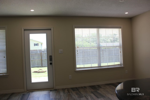 doorway featuring a textured ceiling and dark wood-type flooring