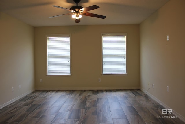 spare room with plenty of natural light, ceiling fan, and dark wood-type flooring