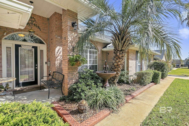 view of exterior entry featuring brick siding