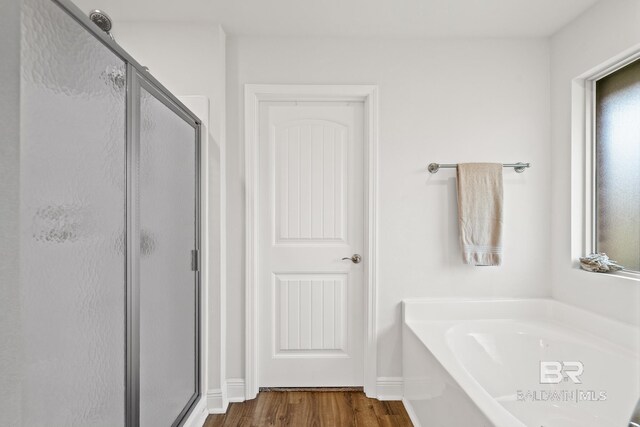 bathroom with hardwood / wood-style floors and independent shower and bath