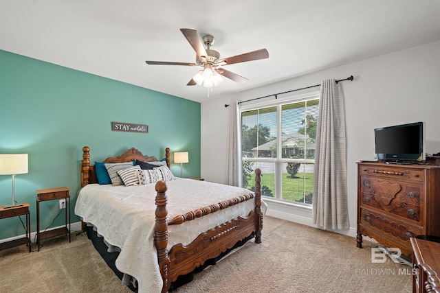 carpeted bedroom featuring multiple windows and ceiling fan