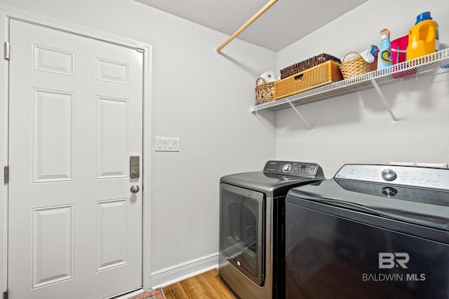 laundry room with separate washer and dryer and light hardwood / wood-style flooring