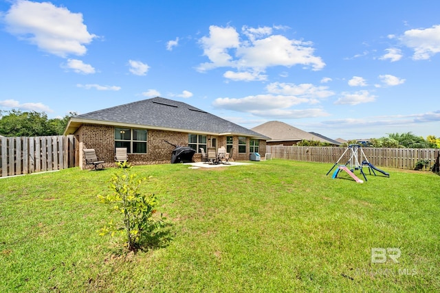 rear view of property featuring a lawn, a playground, and a patio