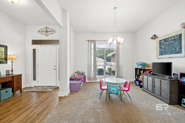 recreation room with hardwood / wood-style floors and an inviting chandelier