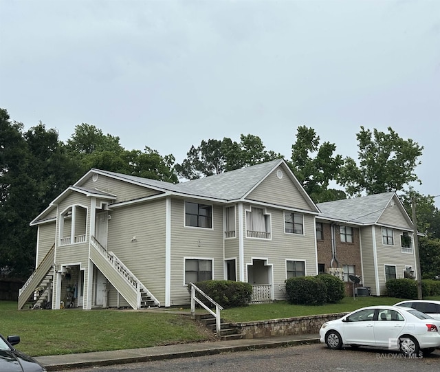 view of front of property with stairs and a front yard
