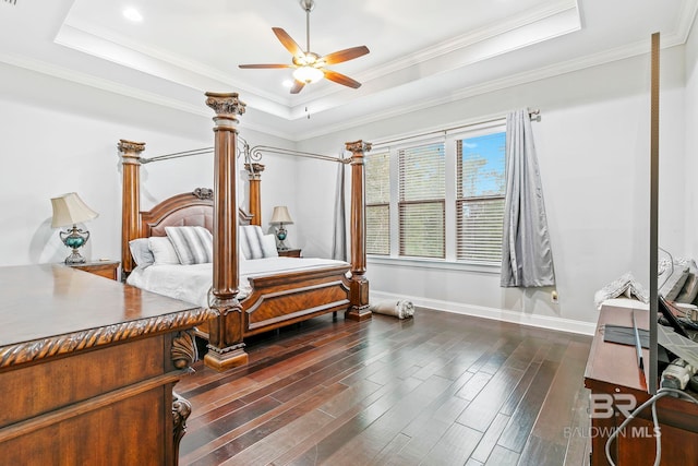 bedroom featuring dark wood-type flooring, ceiling fan, a raised ceiling, and ornamental molding