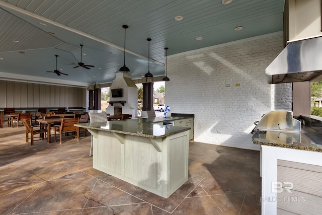 view of patio with exterior bar, area for grilling, an outdoor kitchen, and ceiling fan