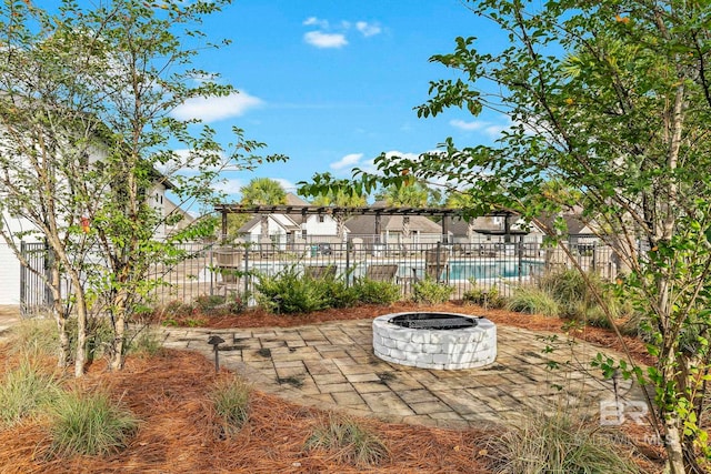 view of yard with a fenced in pool, a patio, and a fire pit