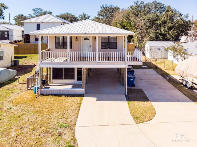 view of front facade with a carport, a porch, and a front lawn