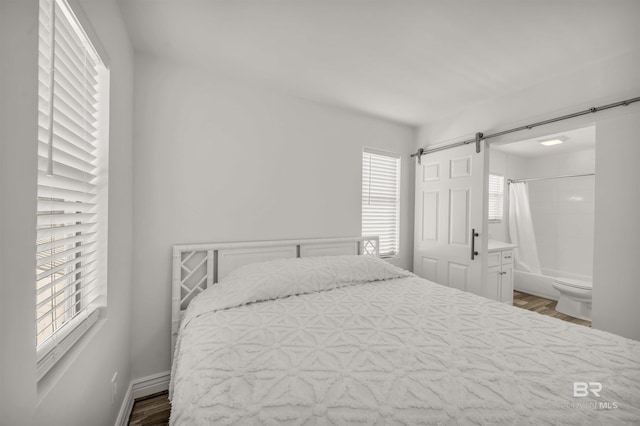 bedroom with connected bathroom and hardwood / wood-style flooring