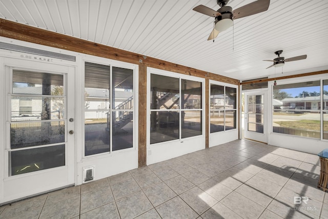 unfurnished sunroom featuring ceiling fan