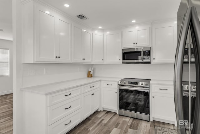 kitchen with white cabinetry, appliances with stainless steel finishes, and light hardwood / wood-style flooring