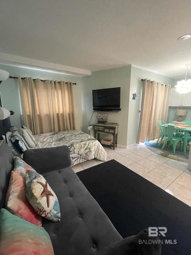 bedroom with a notable chandelier, light tile patterned flooring, and a textured ceiling