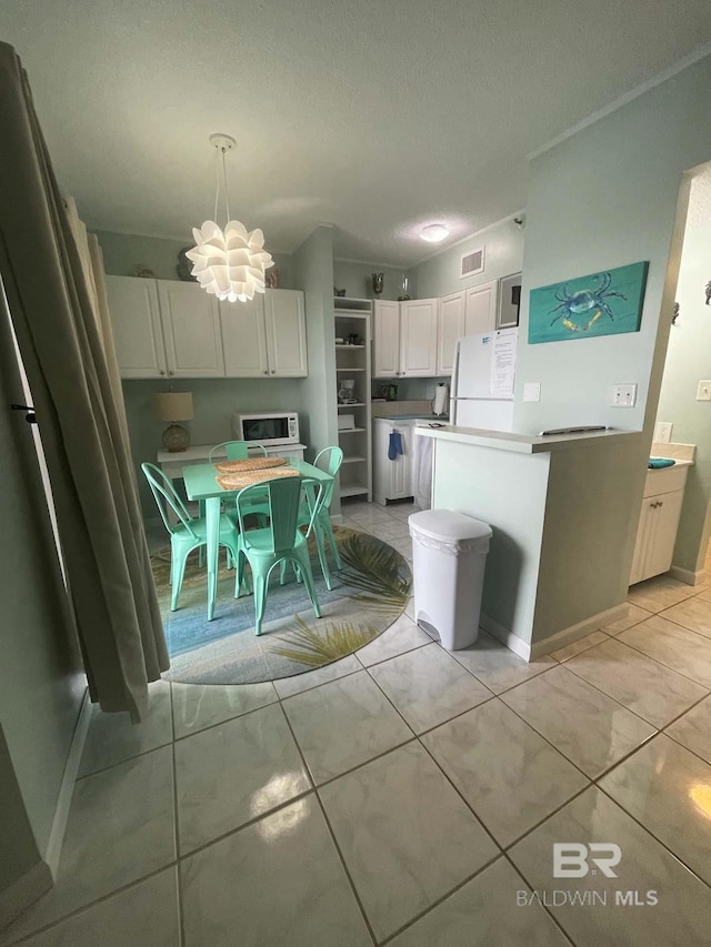 kitchen featuring visible vents, light countertops, an inviting chandelier, white cabinets, and white appliances