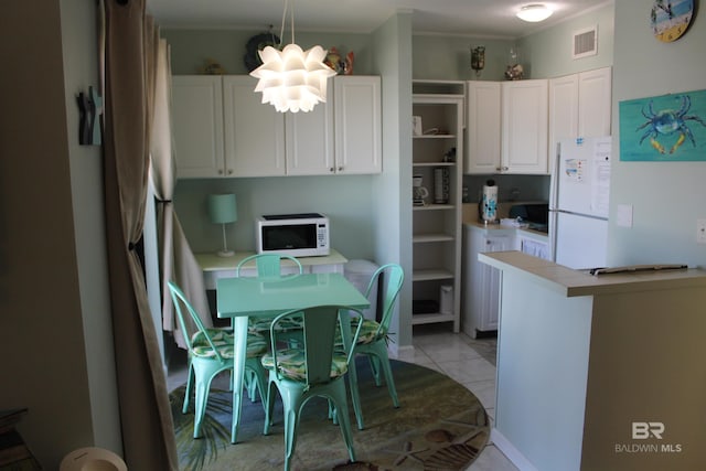 kitchen featuring white appliances, light tile patterned floors, visible vents, light countertops, and white cabinetry