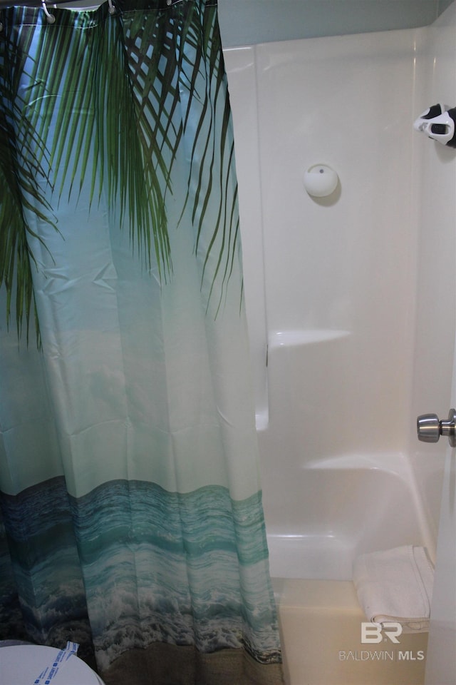 bathroom with curtained shower and a bath