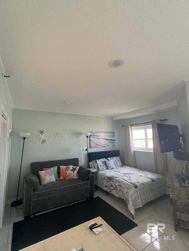 bedroom with light tile patterned floors and a textured ceiling