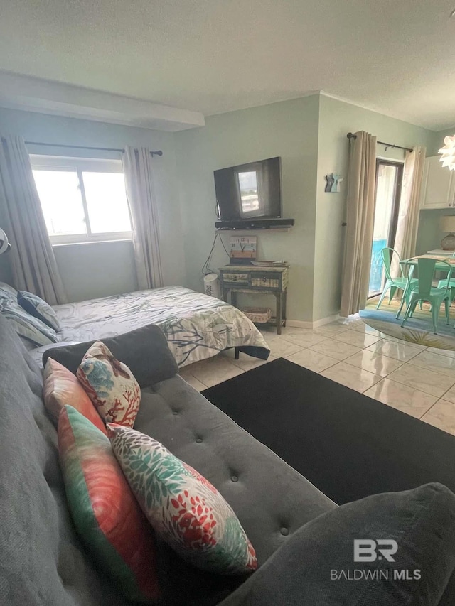 bedroom featuring tile patterned floors, baseboards, and access to exterior