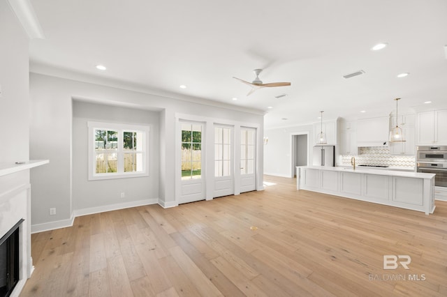 856 Geranium Dr, Fairhope, AL 36532 - unfurnished living room featuring a ceiling fan, light wood-style floors, a fireplace, crown molding, and recessed lighting