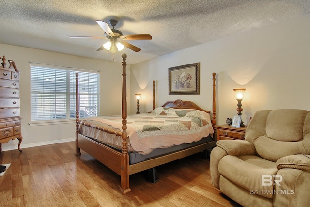 bedroom with a textured ceiling, light hardwood / wood-style floors, and ceiling fan