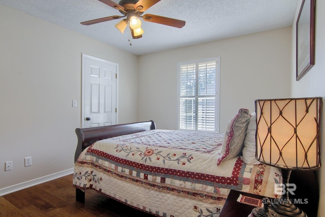 bedroom featuring a textured ceiling, dark wood-type flooring, and ceiling fan