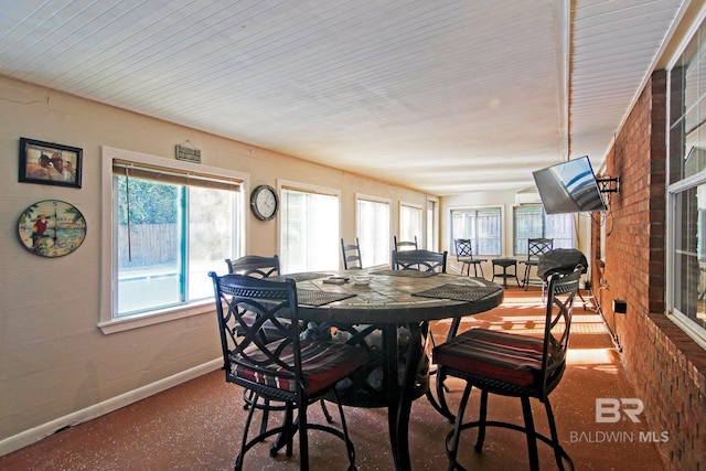 dining space featuring brick wall