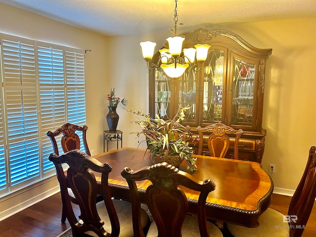 dining room featuring a notable chandelier, a textured ceiling, and dark hardwood / wood-style floors