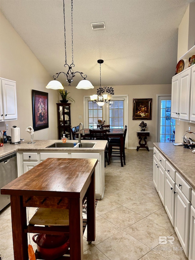 kitchen with sink, hanging light fixtures, lofted ceiling, white cabinets, and an inviting chandelier