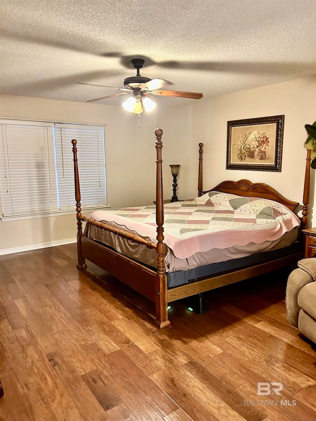 bedroom with a textured ceiling, wood-type flooring, and ceiling fan