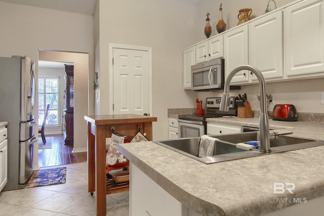 kitchen featuring kitchen peninsula, stainless steel appliances, light wood-type flooring, and white cabinets