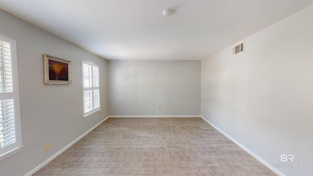 unfurnished room with baseboards and visible vents
