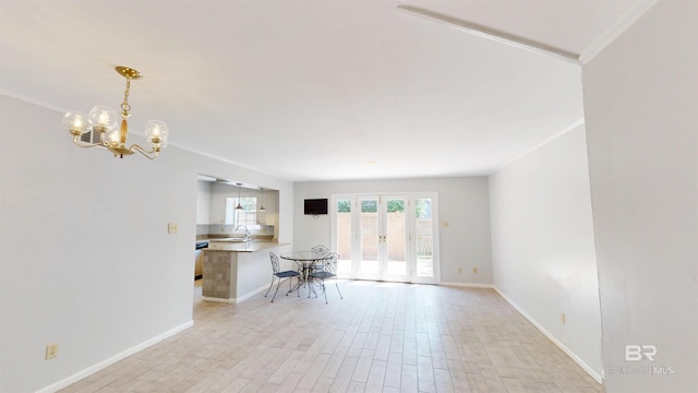 interior space featuring french doors, baseboards, a chandelier, and light wood-style floors