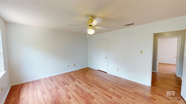spare room with visible vents, a ceiling fan, baseboards, and light wood-type flooring