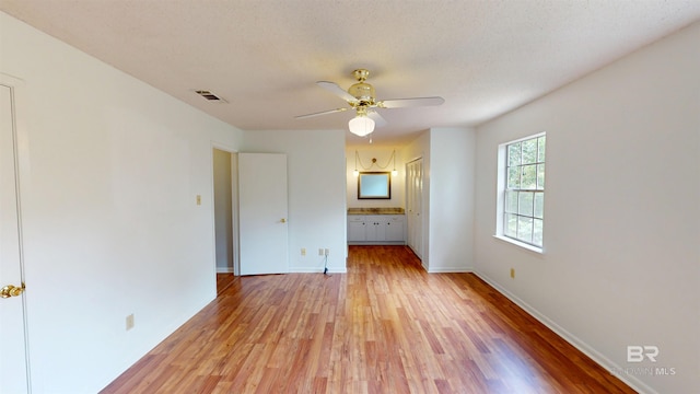 unfurnished room featuring visible vents, a ceiling fan, light wood-style flooring, and baseboards