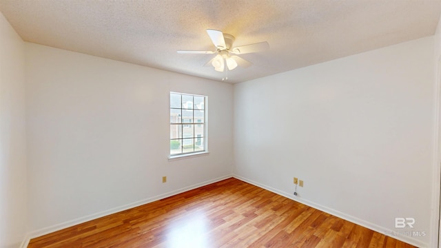 unfurnished room with a ceiling fan, baseboards, light wood-style flooring, and a textured ceiling