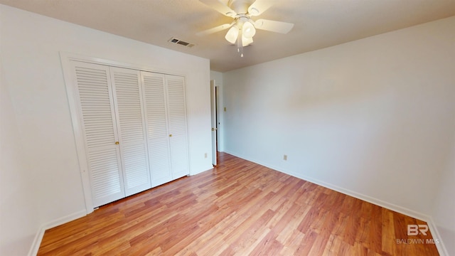 unfurnished bedroom featuring a closet, baseboards, visible vents, and light wood-style floors