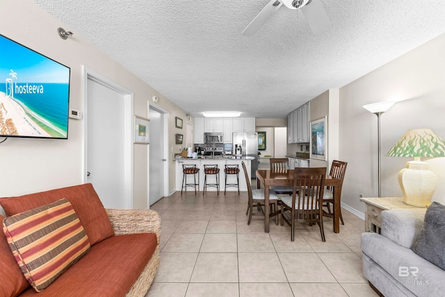 dining space featuring a textured ceiling, light tile patterned floors, and ceiling fan