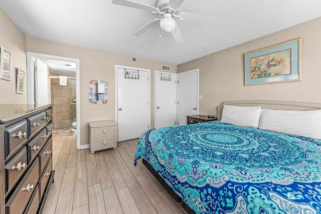 bedroom with a textured ceiling, light hardwood / wood-style floors, ceiling fan, and ensuite bathroom